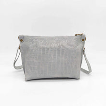 Cargar imagen en el visor de la galería, Bolso bandolera de mujer, piel vacuno, efecto escamas, de tamaño mediano, cierra con cremallera, de LaNievina. Color grisBolso bandolera en piel vacuno, efecto escamas Cuadro pequeño de piel negra cosido como adorno en un de los frontales. Correa de 110 cm. ajustable, en piel del mismo color, con anillas y ganchos en latón envejecido. Interior forrado en tela color negro, con bolsillo cerrado con cremallera. De LaNievina. Color gris, vista trasera