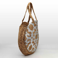 Cargar imagen en el visor de la galería, Bolso de yute redondo, con dibujos tipo étnico en color plateado. Cierra con clip imantado. Ideal para piscina o playa por su gran capacidad. Doble asa para hombro. No forrado. Yute 100%, de LaNievina. Vista lateral