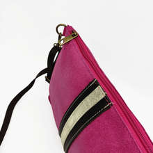 Cargar imagen en el visor de la galería, Bandolera de piel lisa color fucsia de LaNievina, cierra con cremallera y lleva una franja central decorativa en negro y oro. Detalle del cierre con cremallera