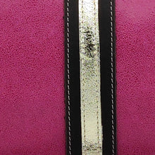 Cargar imagen en el visor de la galería, Bandolera de piel lisa color fucsia de LaNievina, cierra con cremallera y lleva una franja central decorativa en negro y oro. Detalle de la piel