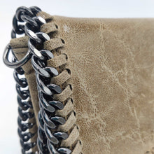 Cargar imagen en el visor de la galería, Bolso de piel de LaNievina, piel aspecto envejecido, con cadenas que adornan los bordes. Cierre clip y cremallera. Llevar cruzado o colgado al hombro, con asa larga de cadena. Color topo. Detalle de la cadena