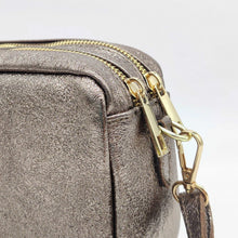 Cargar imagen en el visor de la galería, Bolso bandolera de piel efecto metalizado color bronce de LaNievina. Doble compartimento para llevar todo bien organizado. Asa ajustable. Forrado interior. Cierra con cremallera. Vista detalle de la cremallera