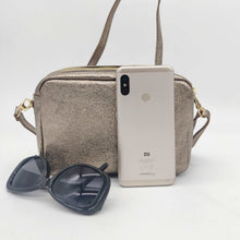 Cargar imagen en el visor de la galería, Bolso bandolera de piel efecto metalizado color bronce de LaNievina. Doble compartimento para llevar todo bien organizado. Asa ajustable. Forrado interior. Cierra con cremallera. Vista con contenido para referencia de tamaño