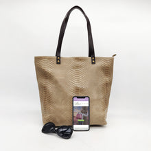 Cargar imagen en el visor de la galería, Bolso de piel tipo tote, efecto escamas, color topo. Tamaño maxi. Dos asas largas de piel para llevar al hombro. Cierre con cremallera completa. Color y estilo muy versátil para todo el año, de LaNievina. Vista con contenido para referencia de tamaño.