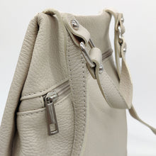 Cargar imagen en el visor de la galería, Mochila de piel lisa. Asa corta para llevar en la mano o brazo, y tirantes ajustables para llevar como mochila. Dos bolsillos delanteros cerrados con cremallera, para llevar a mano las cosas más imprescindibles. Gran capacidad. Muy segura, pues cierra con cremallera por la parte trasera. Interior forrado textil, con bolsillo cerrado con cremallera.La Nievina. Color hueso. Detalle de la piel