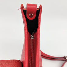 Cargar imagen en el visor de la galería, Bolso de piel color rojo. Puntitos taladrados en el frontal a modo de adorno. Cierra con una tira con clip imantado y cremallera. Asa larga para llevar al hombro. Detalle del cierre