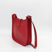 Cargar imagen en el visor de la galería, Bolso de piel color rojo. Puntitos taladrados en el frontal a modo de adorno. Cierra con una tira con clip imantado y cremallera. Asa larga para llevar al hombro. LaNievina. Vista lateral