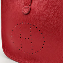 Cargar imagen en el visor de la galería, Bolso de piel color rojo. Puntitos taladrados en el frontal a modo de adorno. Cierra con una tira con clip imantado y cremallera. Asa larga para llevar al hombro. La Nievina. Detalle del frontal