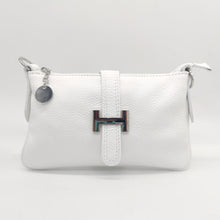 Cargar imagen en el visor de la galería, Bolso de piel blanco, con hebilla en plateado de adorno. Cierre con clip imantado en la parte trasera, y con cremallera. Lleva asa cortita para llevar al hombro, y asa larga austable para llevar colgado. Adornos en color plata. Interior forrado textil, con bolsillo plano con cremallera. LaNievina. Vista frontal