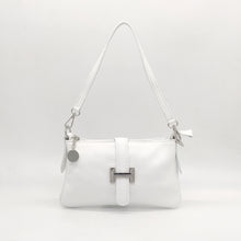 Cargar imagen en el visor de la galería, Bolso de piel blanco, con hebilla en plateado de adorno. Cierre con clip imantado en la parte trasera, y con cremallera. Lleva asa cortita para llevar al hombro, y asa larga austable para llevar colgado. Adornos en color plata. Interior forrado textil, con bolsillo plano con cremallera. LaNievina. Vista con asa corta