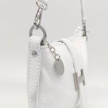 Cargar imagen en el visor de la galería, Bolso de piel blanco, con hebilla en plateado de adorno. Cierre con clip imantado en la parte trasera, y con cremallera. Lleva asa cortita para llevar al hombro, y asa larga austable para llevar colgado. Adornos en color plata. Interior forrado textil, con bolsillo plano con cremallera. LaNievina. Detalle de los adornos color plateado