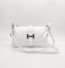 Cargar imagen en el visor de la galería, Bolso de piel blanco, con hebilla en plateado de adorno. Cierre con clip imantado en la parte trasera, y con cremallera. Lleva asa cortita para llevar al hombro, y asa larga austable para llevar colgado. Adornos en color plata. Interior forrado textil, con bolsillo plano con cremallera. LaNievina. Vista con asa larga