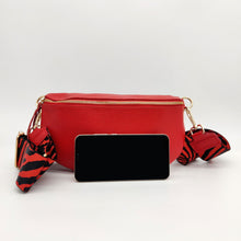 Cargar imagen en el visor de la galería, Bolso de piel lisa tipo riñonera. Cinta ancha (5cm) ajustable, con mosquetones en dorado. Cierre con cremallera. Interior forrado, con bolsillo plano para tarjetas. De LaNievina. Vista con contenido para referencia de tamaño