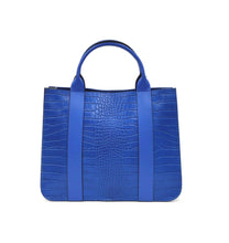 Cargar imagen en el visor de la galerÃa, Bolso de mano de piel efecto escamas azul cobalto de LaNievina. Tiene dos asas cortas con bolsillo frontal y correa por si quiere llevarse al hombro en algun momento. Interior forrado de piel, con bolsillo interior. Cierre de cremallera. Vista trasera