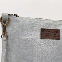 Cargar imagen en el visor de la galería, Bolso bandolera de mujer, piel vacuno, efecto escamas, de tamaño mediano, cierra con cremallera, de LaNievina. Color grisBolso bandolera en piel vacuno, efecto escamas Cuadro pequeño de piel negra cosido como adorno en un de los frontales. Correa de 110 cm. ajustable, en piel del mismo color, con anillas y ganchos en latón envejecido. Interior forrado en tela color negro, con bolsillo cerrado con cremallera. De LaNievina. Color gris,detalle de la piel