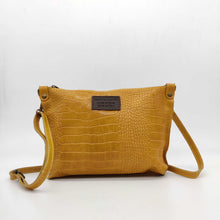Cargar imagen en el visor de la galería, Bolso bandolera en piel vacuno, efecto escamas Cuadro pequeño de piel negra cosido como adorno en un de los frontales. Correa de 110 cm. ajustable, en piel del mismo color, con anillas y ganchos en latón envejecido. Interior forrado en tela color negro, con bolsillo cerrado con cremallera. De LaNievina. Color mostaza. vista frontal