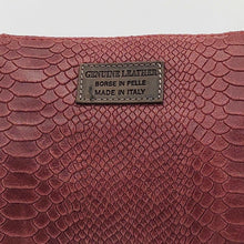 Cargar imagen en el visor de la galería, Bolso bandolera de mujer, piel vacuno, efecto escamas, de tamaño mediano, cierra con cremallera, de LaNievina. Color grisBolso bandolera en piel vacuno, efecto escamas Cuadro pequeño de piel negra cosido como adorno en un de los frontales. Correa de 110 cm. ajustable, en piel del mismo color, con anillas y ganchos en latón envejecido. Interior forrado en tela color negro, con bolsillo cerrado con cremallera. De LaNievina. Color burdeos, detalle de la piel