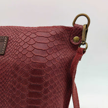Cargar imagen en el visor de la galería, Bolso bandolera de mujer, piel vacuno, efecto escamas, de tamaño mediano, cierra con cremallera, de LaNievina. Color grisBolso bandolera en piel vacuno, efecto escamas Cuadro pequeño de piel negra cosido como adorno en un de los frontales. Correa de 110 cm. ajustable, en piel del mismo color, con anillas y ganchos en latón envejecido. Interior forrado en tela color negro, con bolsillo cerrado con cremallera. De LaNievina. Color burdeos, detalle de la piel