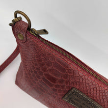 Cargar imagen en el visor de la galería, Bolso bandolera de mujer, piel vacuno, efecto escamas, de tamaño mediano, cierra con cremallera, de LaNievina. Color grisBolso bandolera en piel vacuno, efecto escamas Cuadro pequeño de piel negra cosido como adorno en un de los frontales. Correa de 110 cm. ajustable, en piel del mismo color, con anillas y ganchos en latón envejecido. Interior forrado en tela color negro, con bolsillo cerrado con cremallera. De LaNievina. Color burdeos detalle piel y cremallera