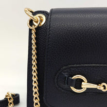 Cargar imagen en el visor de la galería, Bolso de piel con cadena Géminis, de LaNievina, con adorno metálico en el frontal y asa de cadena con hombrera, vista frontal, detalle de la piel y cadena dorada