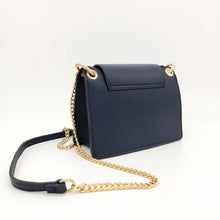 Cargar imagen en el visor de la galería, Bolso de piel con cadena Géminis, de LaNievina, con adorno metálico en el frontal y asa de cadena con hombrera, vista trasera, color azul marino y cadena dorada