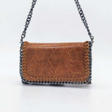 Cargar imagen en el visor de la galería, Bolso de piel de LaNievina, piel aspecto envejecido, con cadenas que adornan los bordes. Cierre clip y cremallera. Llevar cruzado o colgado al hombro, con asa larga de cadena. Color topo. Color camel, vista con asa