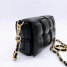 Cargar imagen en el visor de la galería, Bolso negro de piel acolchado con cadena dorada con tira de piel interior, con bolsillo extraíble, de LaNievina. Vista lateral