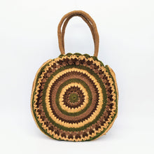 Cargar imagen en el visor de la galería, Bolso redondo de colores de crochet en lana acrílica. Dos asas cortas y otra larga de lana trenzada, de LaNievina. Asas cortas para llevar en el brazo u hombro. Tonos marrones y verdes