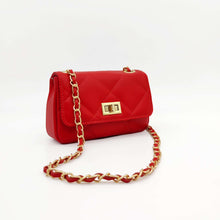 Cargar imagen en el visor de la galería, Bolso de piel acolchado rombos, color rojo de LaNievina, con cadenaBolso acolchado de piel en color rojo. Solapa con cierre giratorio metálico dorado. Asa larga de cadena dorada y piel. Interior forrado en tela, con bolsillo cerrado con cremallera. LaNievina. Vista lateral con cadena

