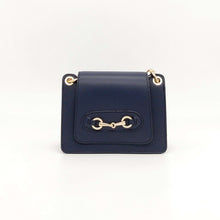Cargar imagen en el visor de la galería, Bolso de piel con cadena Géminis, de LaNievina, con adorno metálico en el frontal y asa de cadena con hombrera, vista frontal
